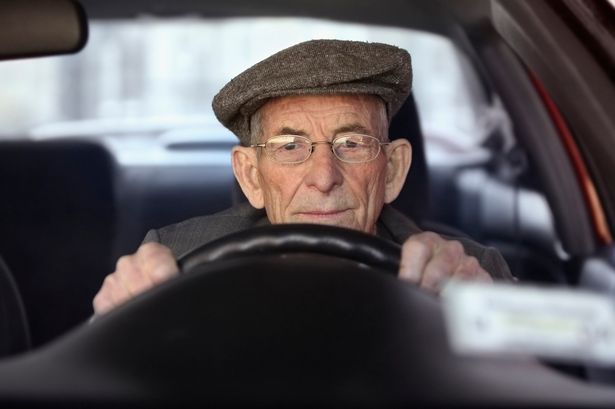 A senior man driving a car